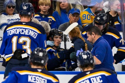 Blues player hit in neck with puck, keeps playing before eventually being stretchered off