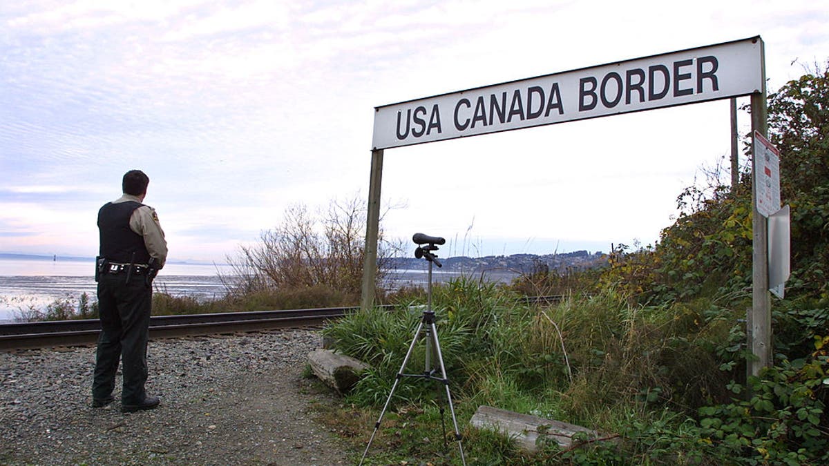 A Canadian Customs and Fisheries officer watches over the U.S.-Canada border between Blaine, Washington and White Rock, British Columbia.