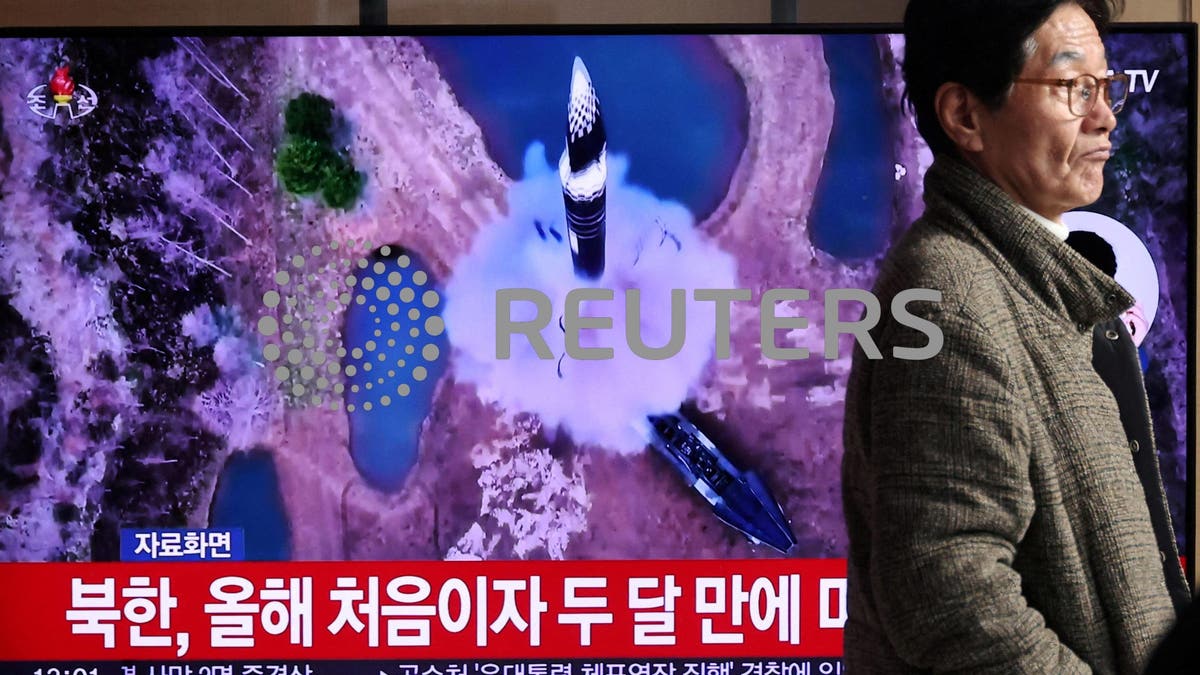 A man walks past a TV broadcasting a news report on North Korea firing a ballistic missile out to sea off its east coast, in Seoul, South Korea.