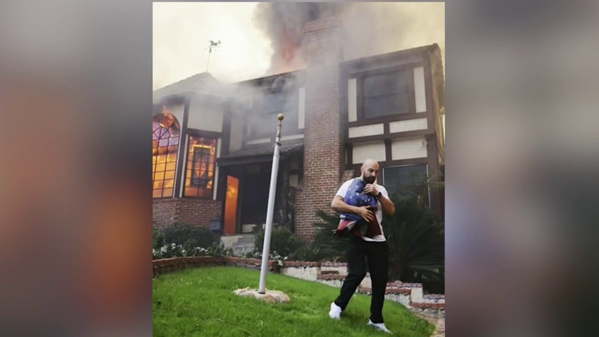 Sultan Ramazanov carries an American flag from a burning home in Altadena, California during the wildfires.