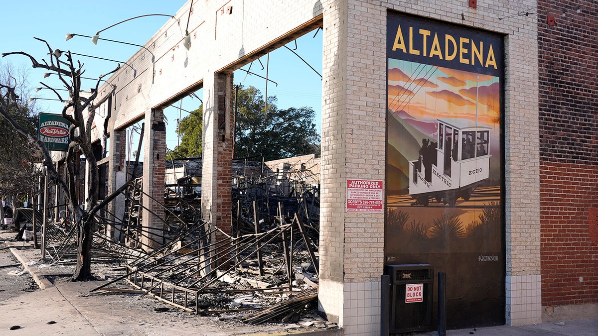 A wall mural depicting Altadena stands next to the destroyed Altadena Hardware store after the Eaton Fire