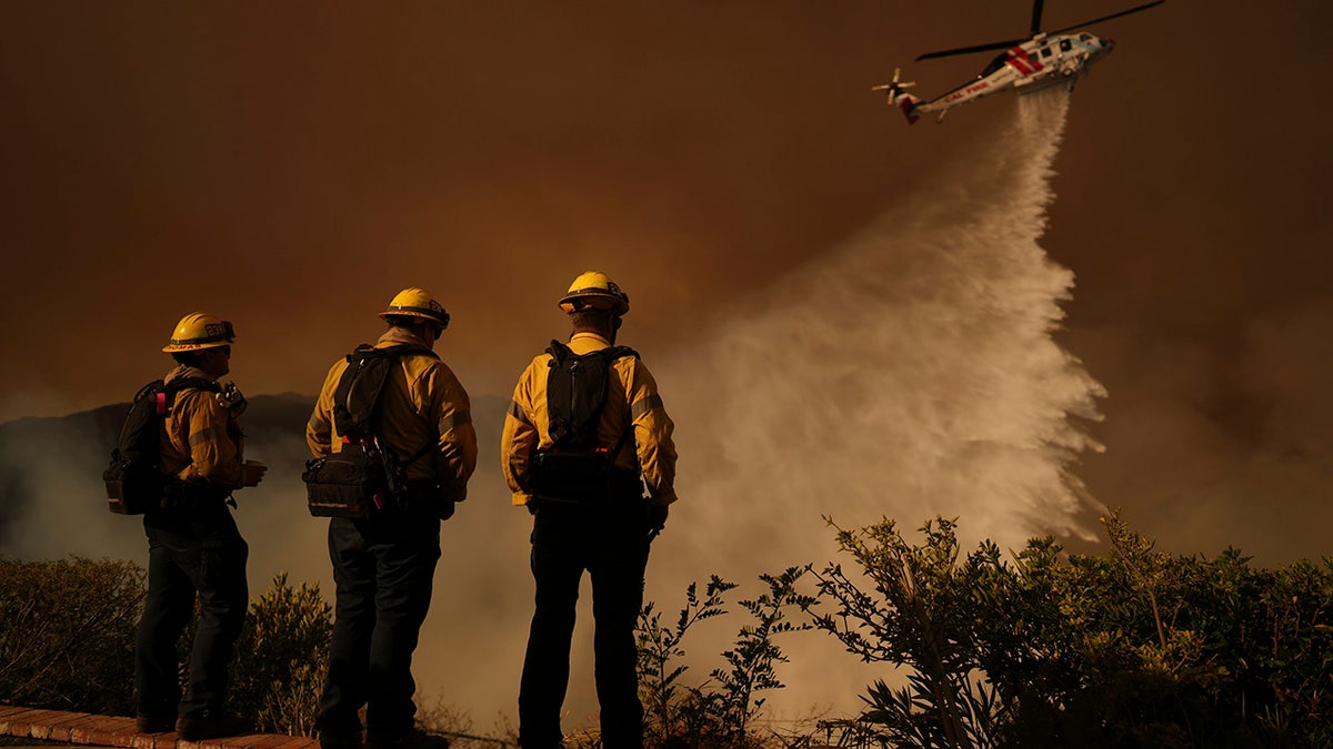 Water is dropped by helicopter on the Palisades Fire