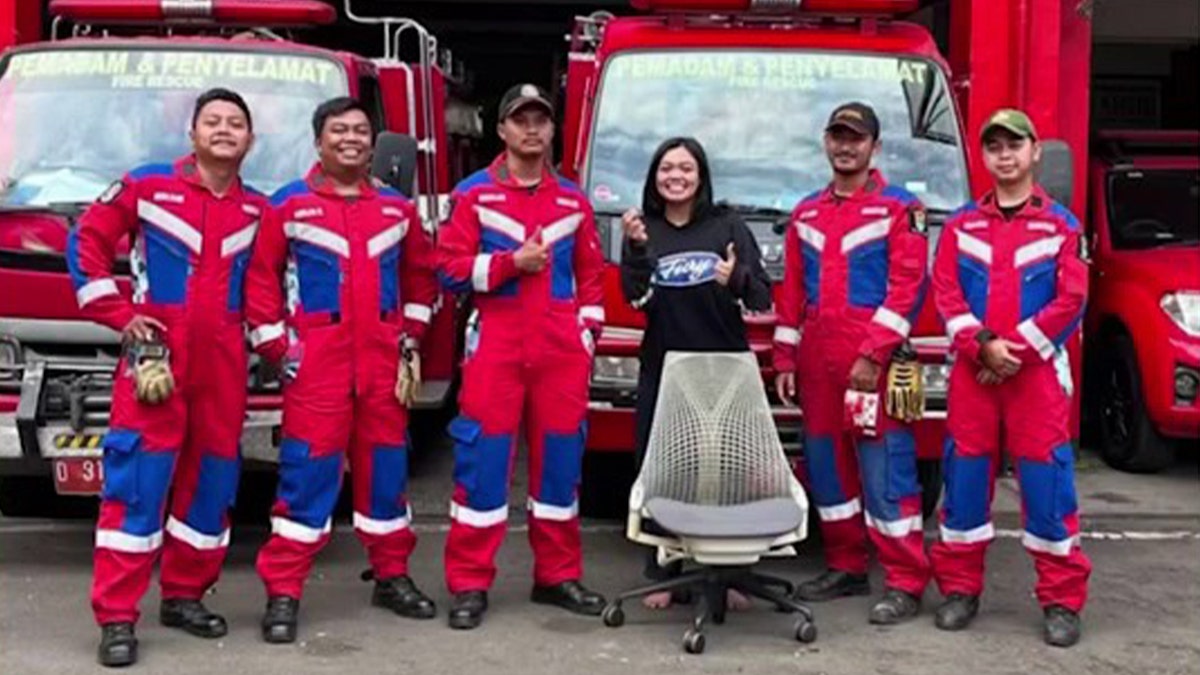 Woman poses with firefighters after rescue