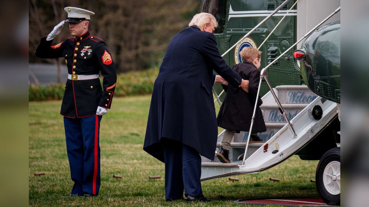 President Donald Trump lifts Elon Musk's son, "Lil X," onto the steps of Marine Force One