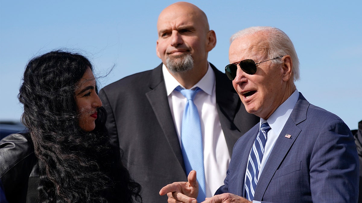 President Biden talks with Gisele Barreto Fetterman while Pennsylvania Senate candidate John Fetterman stands nearby