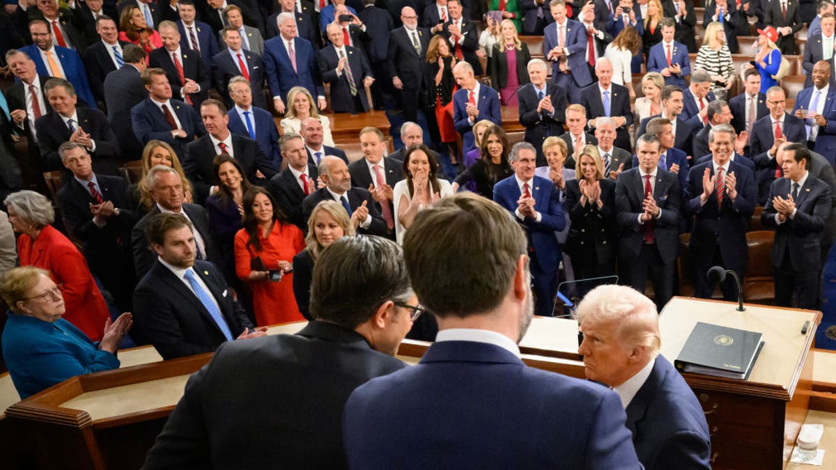 Republican lawmakers applaud as U.S. President Donald Trump shakes hands with House Speaker Mike Johnson (R-LA) (L) and Vice President JD Vance (R) and as he arrives to deliver his address to a joint session of Congress at the U.S. Capitol