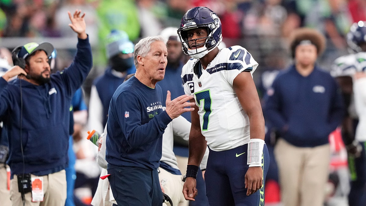 Pete Carroll talks with Geno Smith