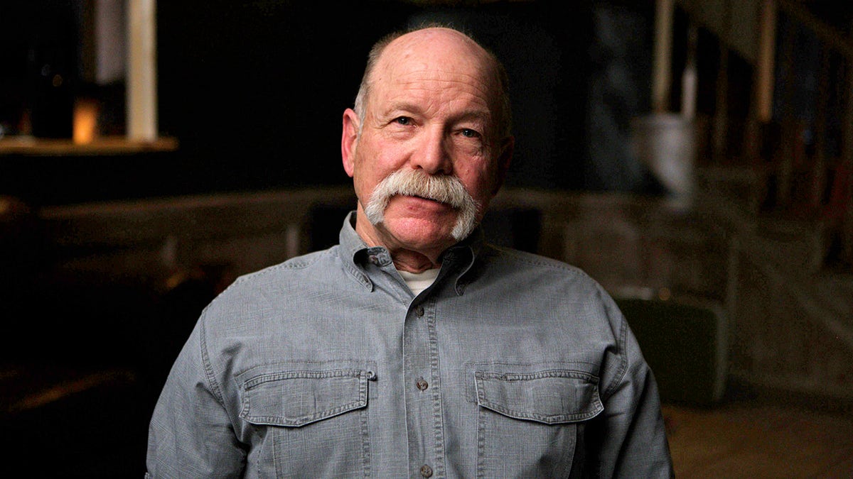 A close-up of Mike Shannon wearing a denim shirt.