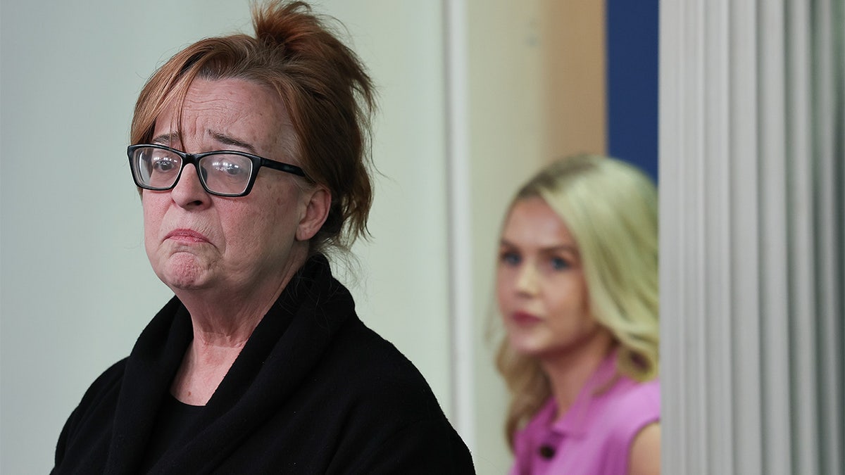 Patty Morin, crying and wearing a black sweater and shirt, and White House Press secretary Karolina Leavitt, wearing a pink dress, at a press briefing