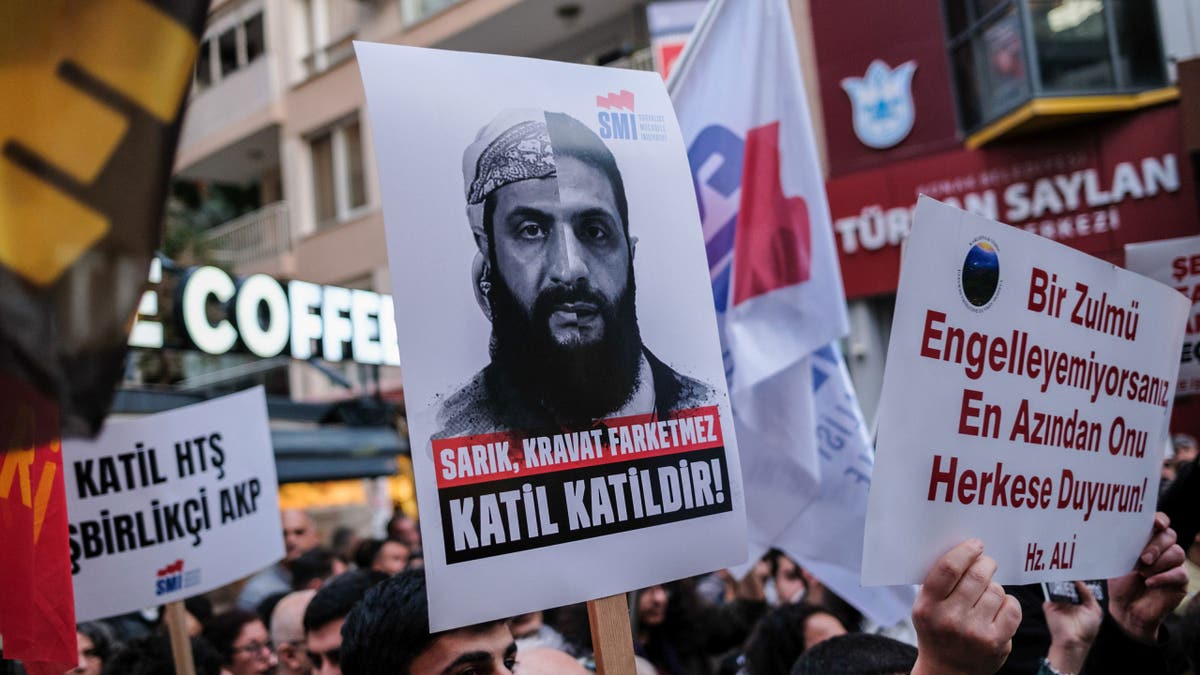 Protesters hold signs