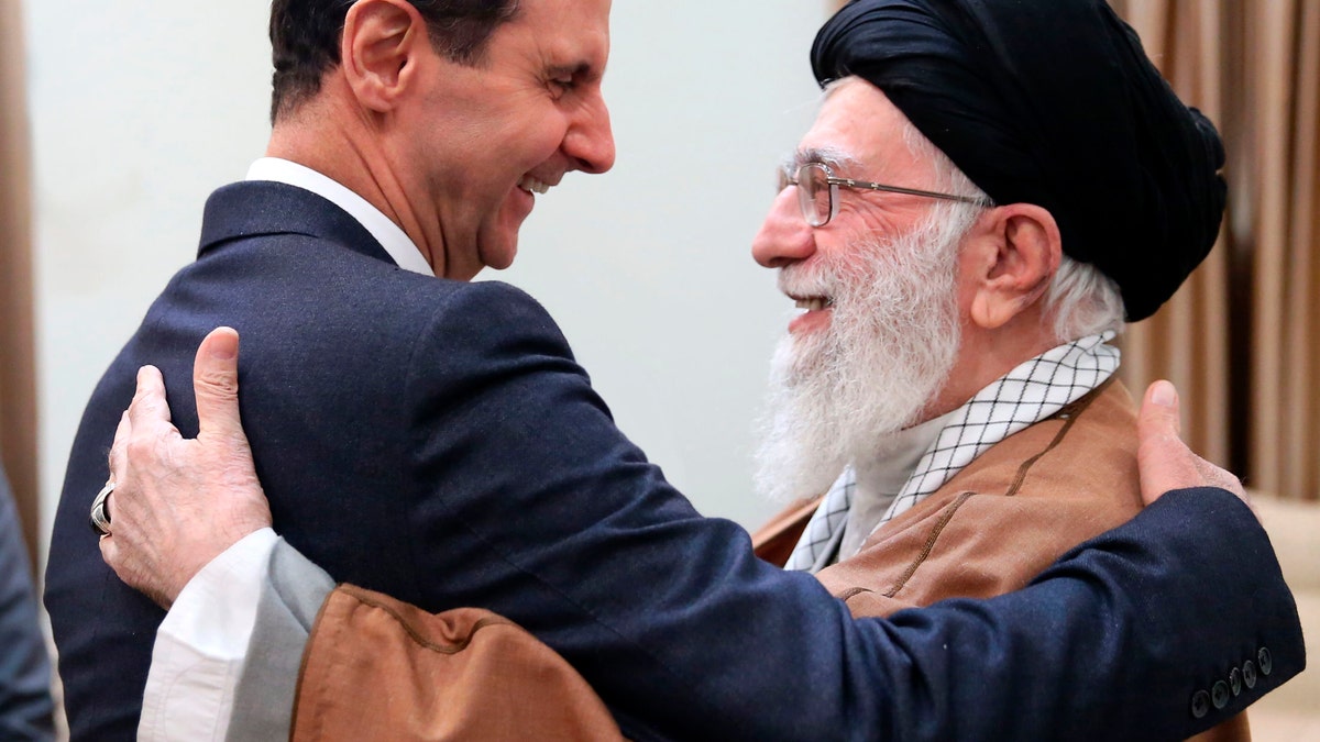 Supreme Leader Ayatollah Ali Khamenei hugs then-Syrian President Bashar Assad