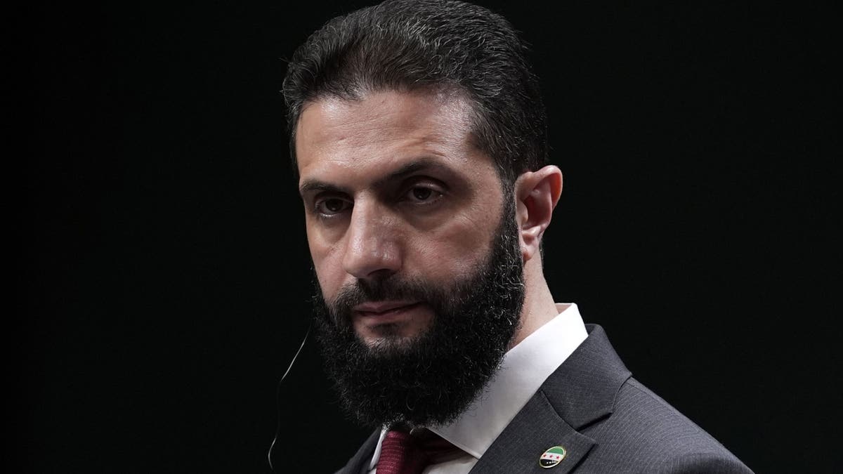 Ahmad al-Sharaa wearing a grey suit jacket