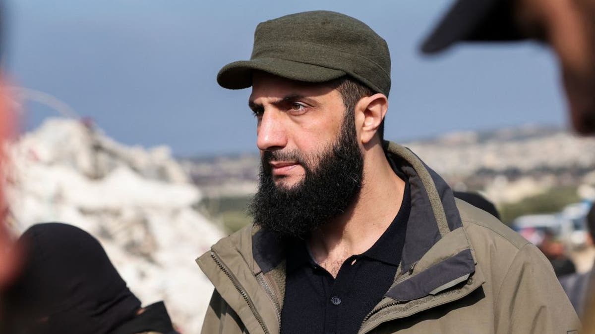 Hayat Tahrir al-Sham wearing a dark green hat and jacket