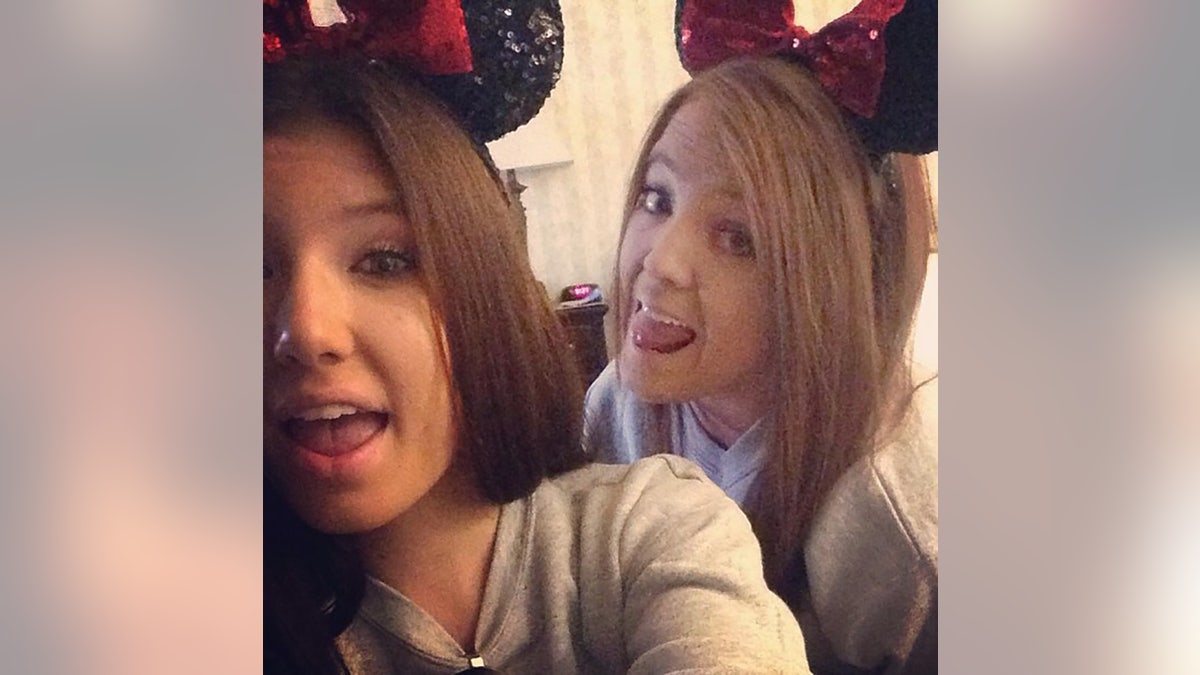 Baylee Despot taking a selfie with another young woman wearing Mickey Mouse ears