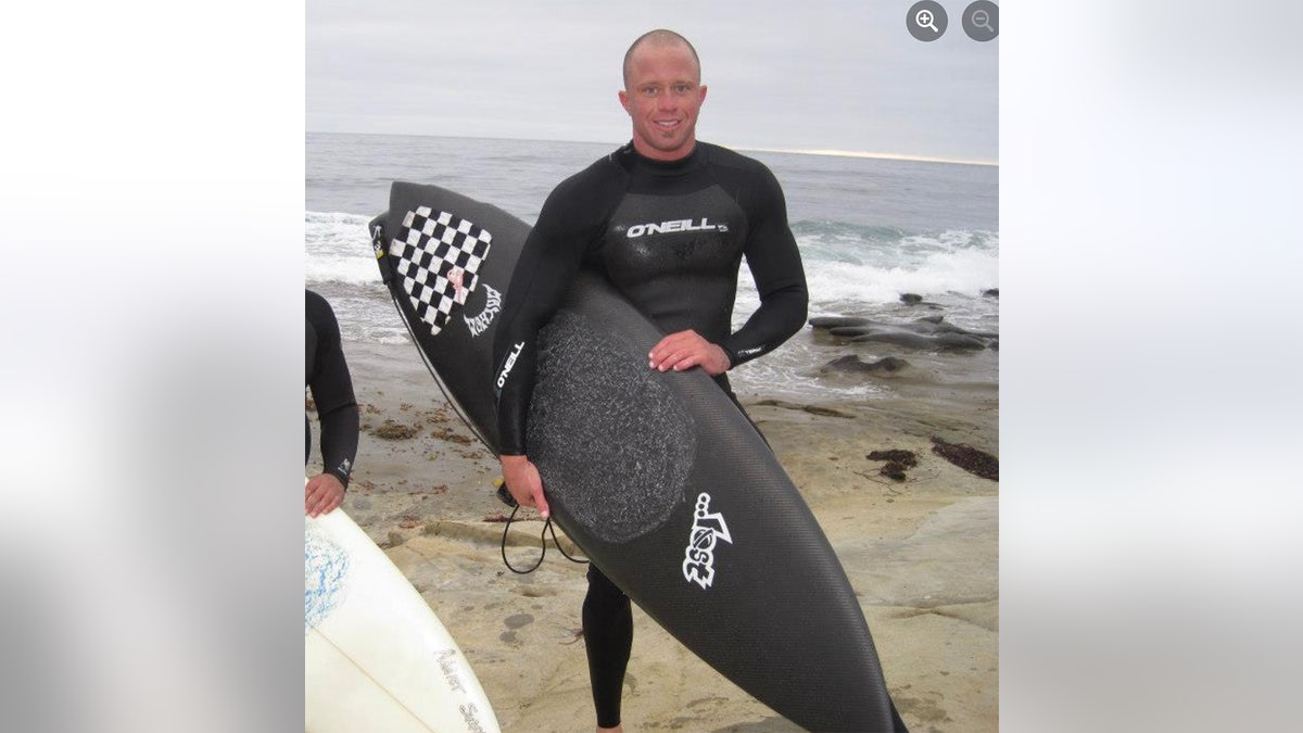 James Kulstad hold surfboard at beach