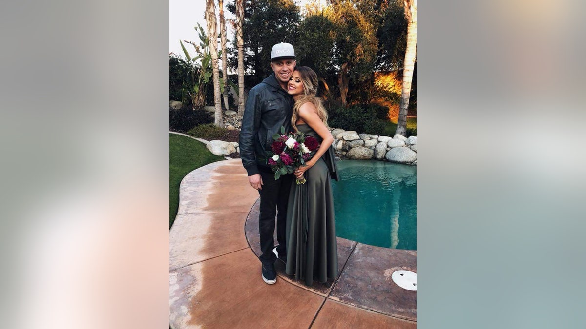 James Kulstad being embraced by a woman near a pool.
