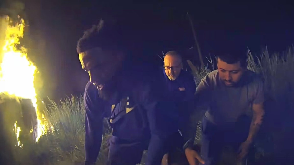 A screenshot of the crash footage showing Good Samaritans helping pull the victim to safety