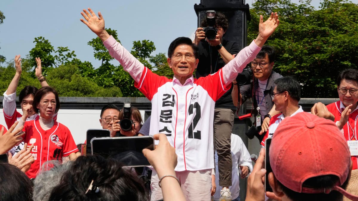 Kim Moon-soo with his arms up