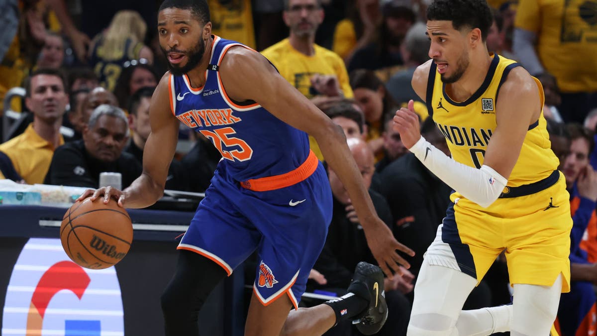 New York Knicks forward Mikal Bridges (25) dribbles the ball defended by Indiana Pacers guard Tyrese Haliburton (0) in the third quarter during game six of the eastern conference finals for the 2025 NBA Playoffs at Gainbridge Fieldhouse.
