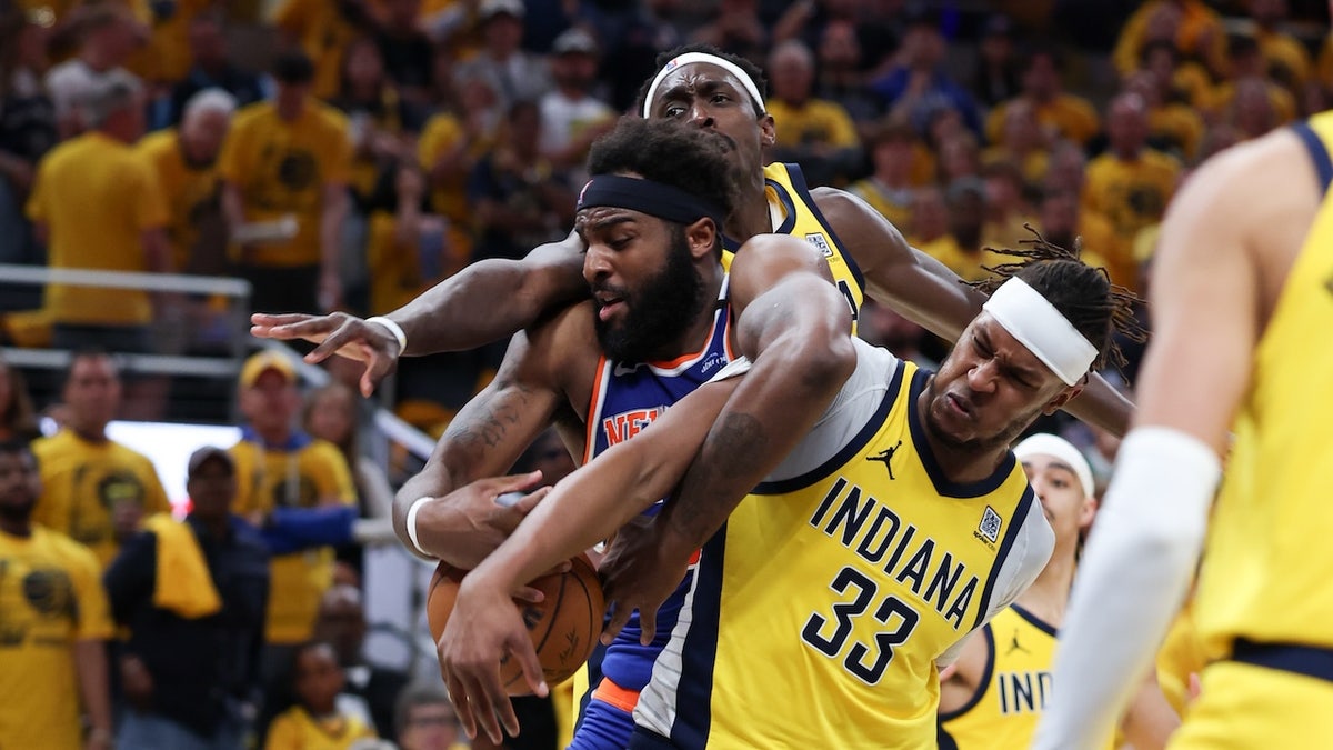 New York Knicks center Mitchell Robinson (23) battles for the ball against Indiana Pacers forward Pascal Siakam (43) and center Myles Turner (33) in the third quarter during game six of the eastern conference finals for the 2025 NBA Playoffs at Gainbridge Fieldhouse.