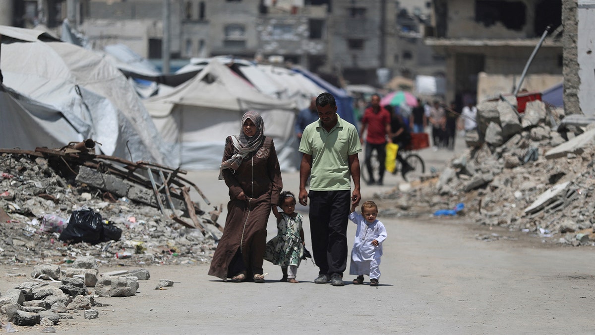 Palestinians walk through rubble in Gaza
