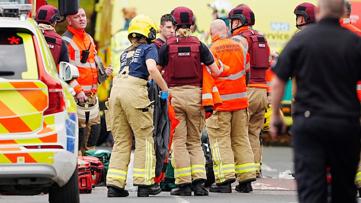 Firefighters and paramedics respond outside Heaton Park Hebrew Congregation Synagogue in Manchester, England, Thursday, Oct. 2, 2025, after a car was driven into pedestrians and a man was stabbed. Police said four people were injured and the suspect was shot by officers.