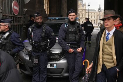 Mystery man in dapper suit goes viral after appearing in Louvre heist investigation photo