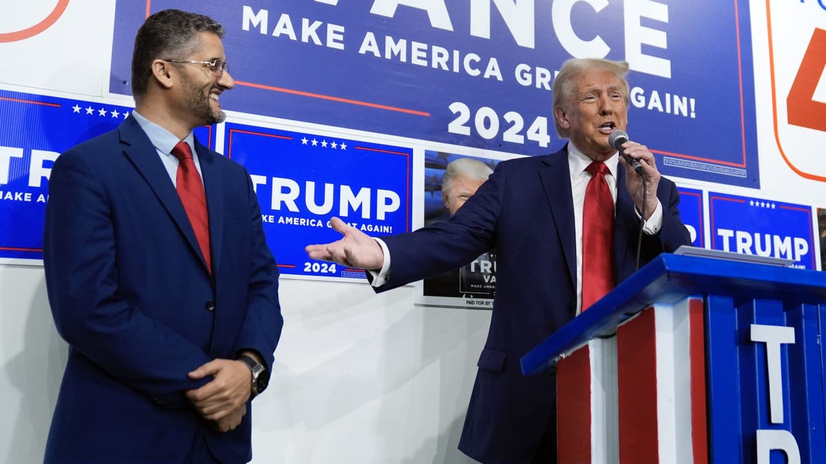Republican presidential nominee former President Donald Trump speaks as Hamtranck Mayor Amer Ghalib looks on