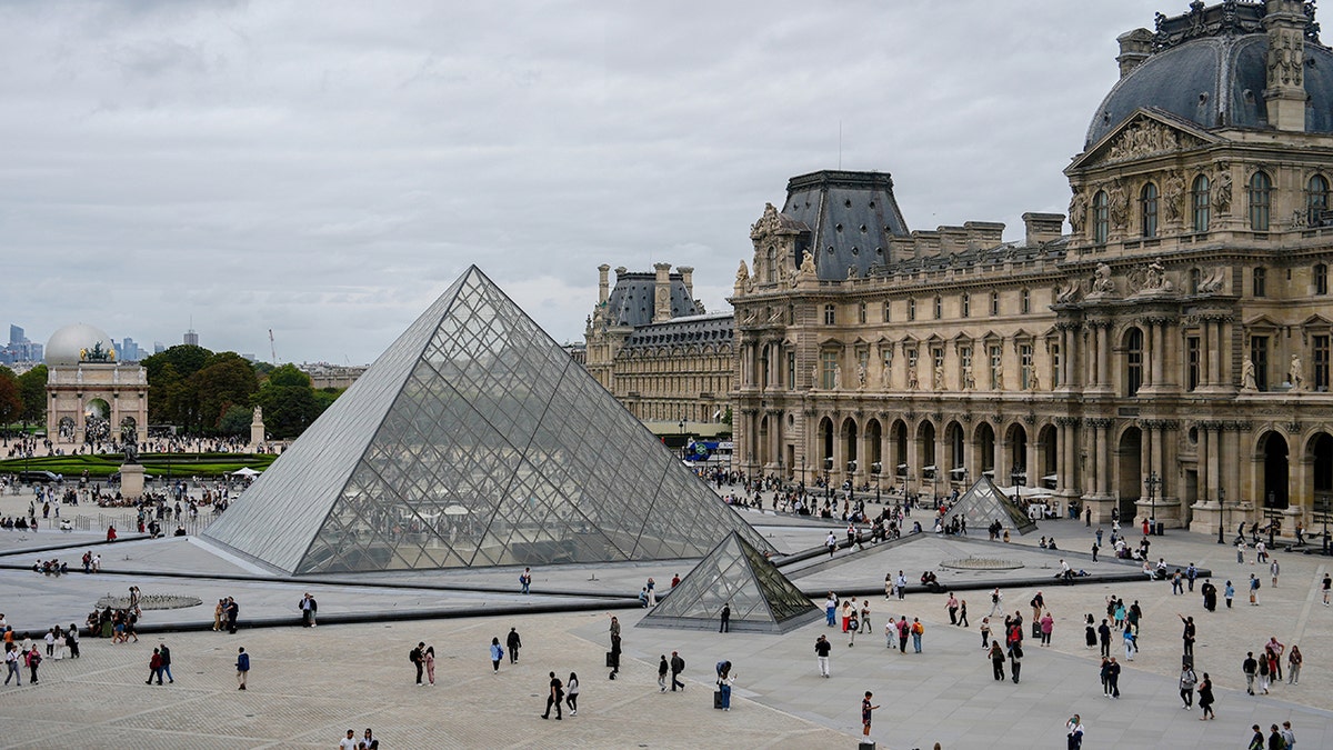 People walk outside the Louvre museum