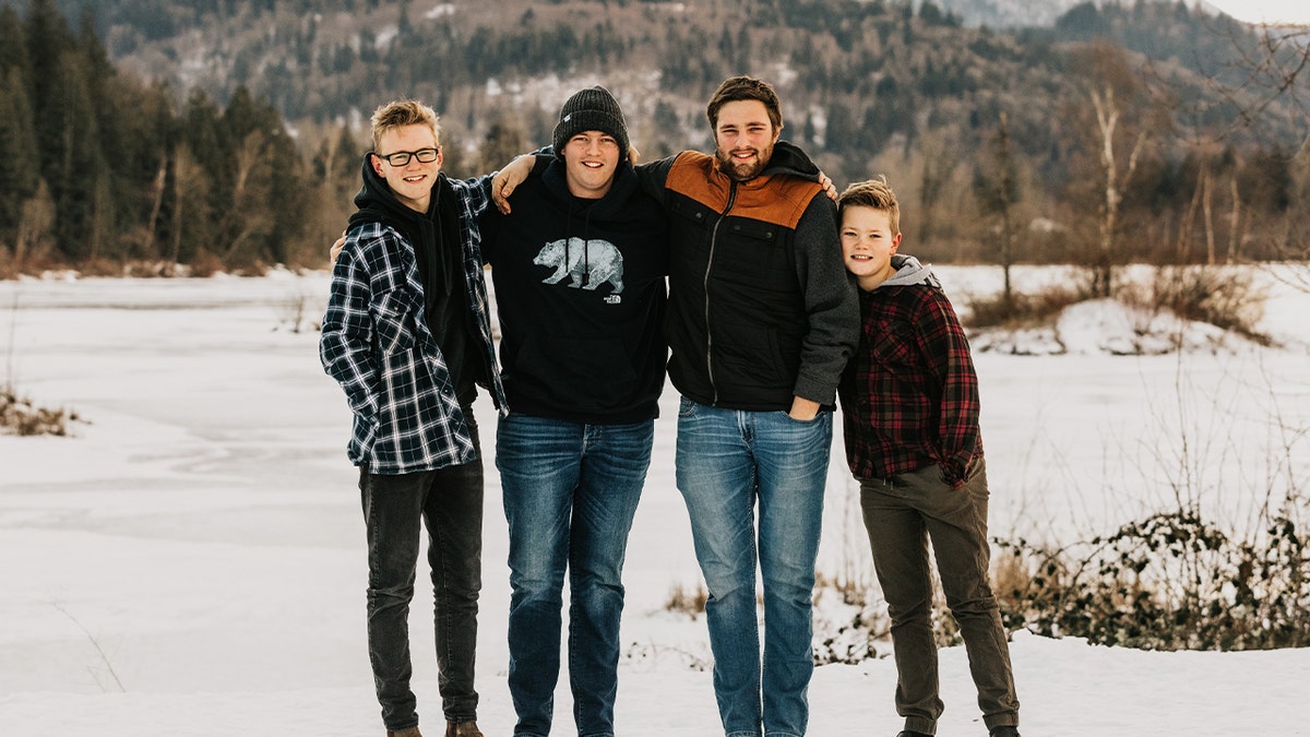 Markus Schouten poses outdoors in a snowy landscape with three other men, all wearing winter clothing and smiling for the camera.