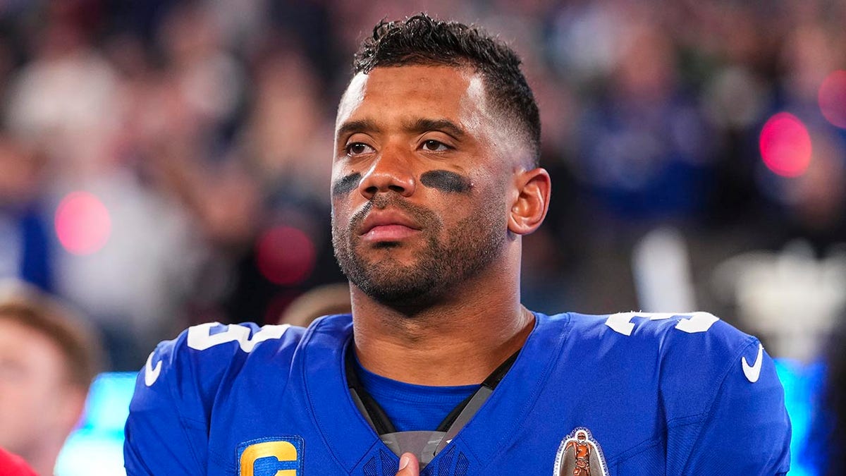 Russell Wilson looks on during national anthem