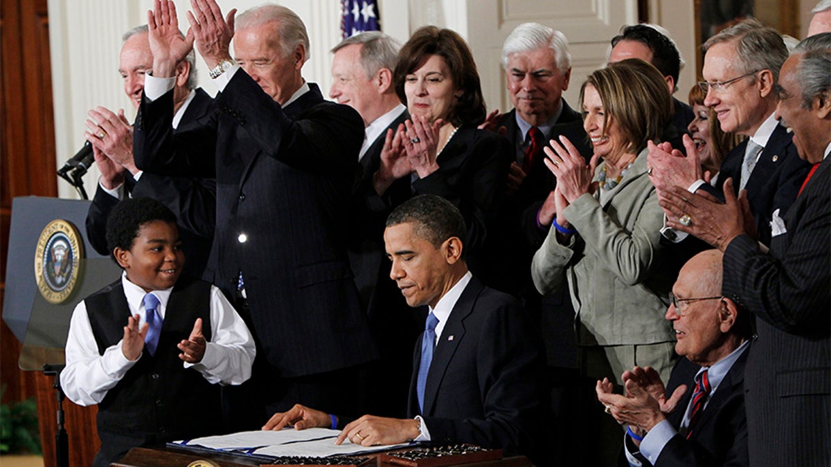 FILE -In this March 23, 2010, file photo President Barack Obama is applauded after signing the Affordable Care Act into law in the East Room of the White House in Washington. If the law survives Supreme Court scrutiny, it will be nearly a decade before all its major pieces are in place, and even if he is re-elected, Obama won't be in office to oversee completion of his biggest domestic policy accomplishment, assuming Republicans don't succeed in repealing it. The law's carefully orchestrated phase-in is evidence of what's at stake in the Supreme Court deliberations that start March 26, 2012. (AP Photo/Charles Dharapak, File)