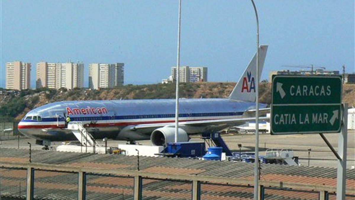 FILE - In this Jan. 26, 2007 file photo, an American Airlines plane sits on the tarmac at Simon Bolivar International Airport in Maiquetia, Venezuela. American Airlines said Tuesday, June 17, 2014 that it will cut nearly 80 percent of its flights to Venezuela in a dispute over revenue being held by the South American country. (AP Photo/Rafael Moreno, File)