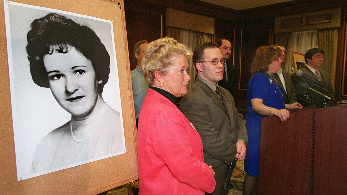 Casey Sherman standing next to his mother and a portrait of his aunt Mary Sullivan.