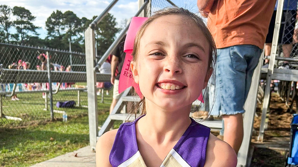 Delyla in a cheerleading uniform at an event.