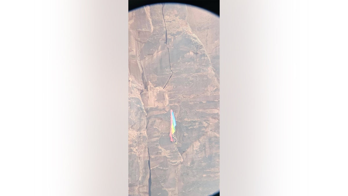 Photo of a BASE jumper on the face of the Grand Canyon in Moab, Utah through a binocular view