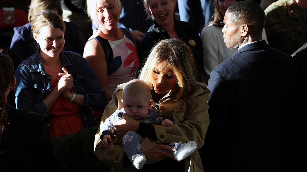 First Lady Melania Trump holds a baby at Marine Corps visit