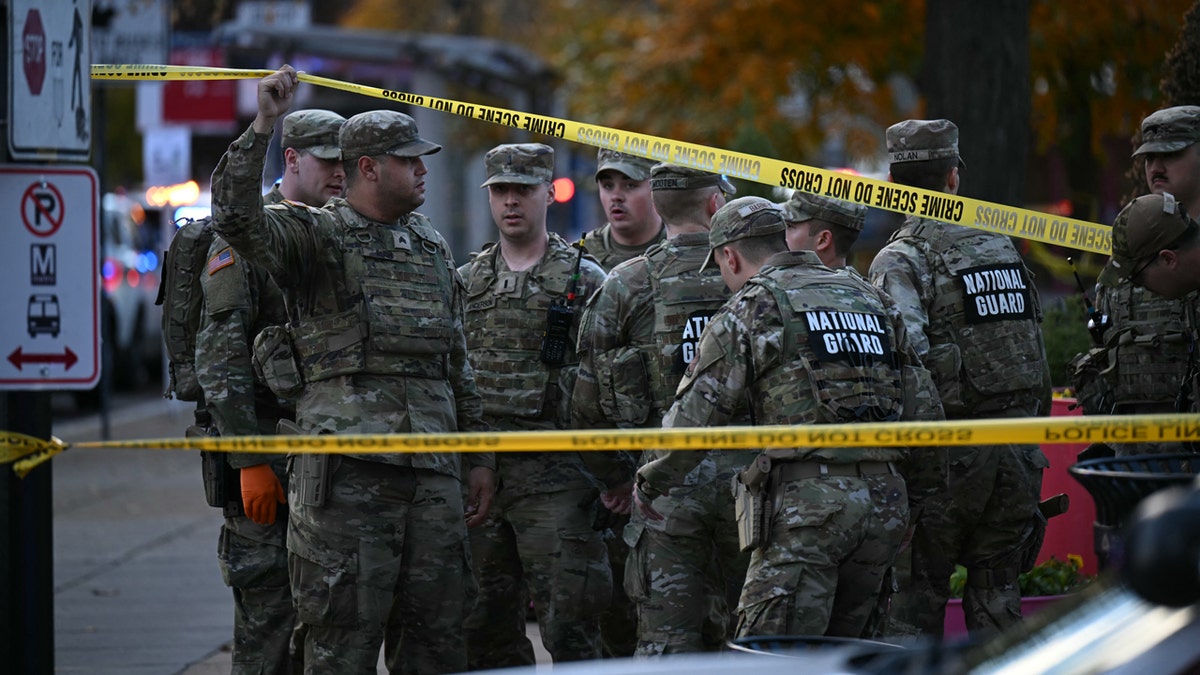 National Guard soldiers stand behind the crime scene tape at a corner in downtown Washington, D.C., on Wednesday. Two National Guard soldiers were shot a few blocks from the White House, according to law enforcement.