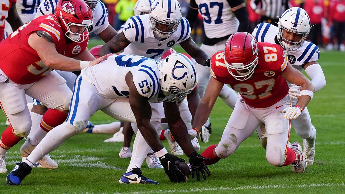Travis Kelce fights for a loose ball