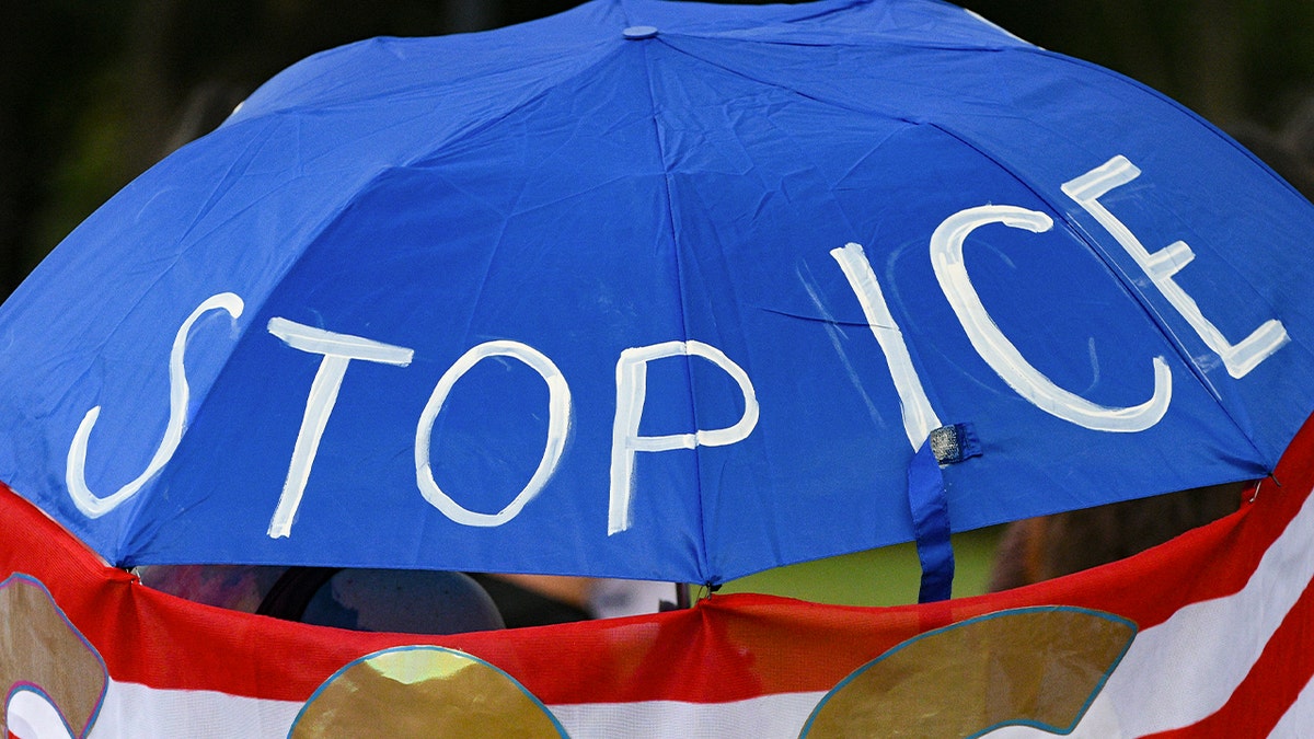 Umbrella reads "Stop ICE"