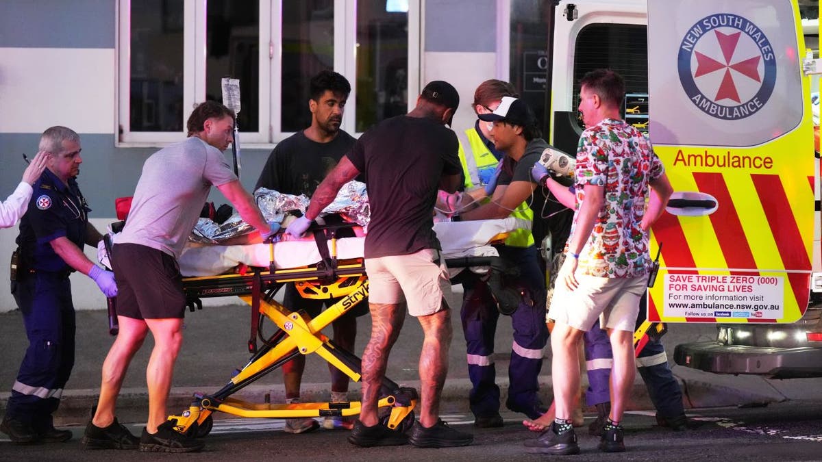 People surround a stretcher at the scene of a shooting in Australia