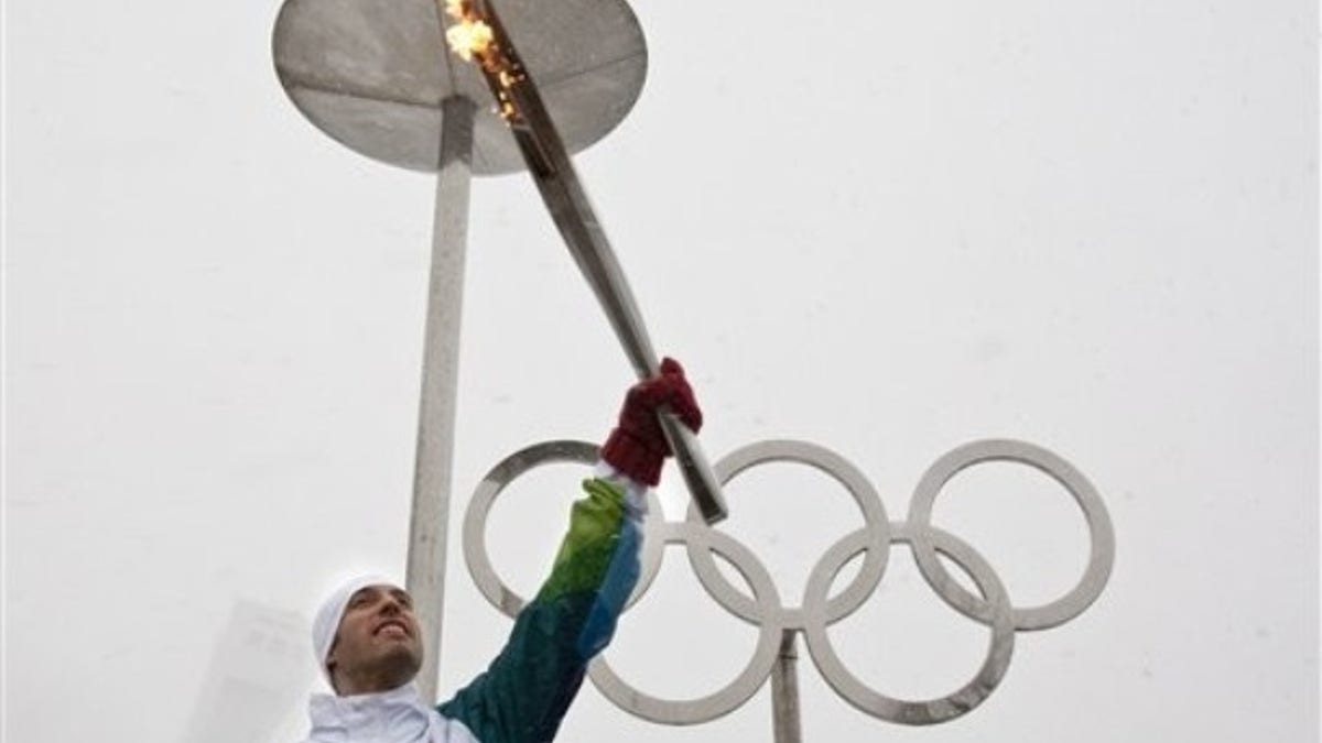 Short-track speedskater Jean-Francois Monette lights the Olympic flame at Montreal's Olympic Stadium during the Olympic Torch relay Wednesday, Dec. 9, 2009 in Montreal. (AP Photo/The Canadian Press, Paul Chiasson)