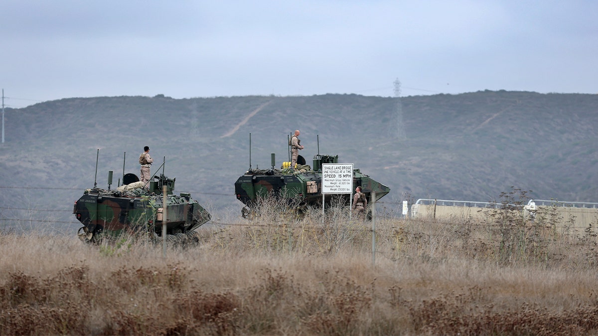 soldiers standing of combat vehicles in field