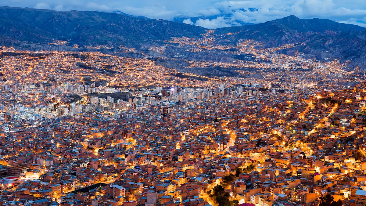 Downtown district of La Paz with lots of living houses scattered on the hills and snow capped mountain Illimani (part of the Cordillera Oriental, a subrange of the Andes) in the background, Bolivia.