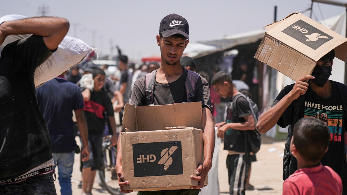 Palestinians carry humanitarian aid