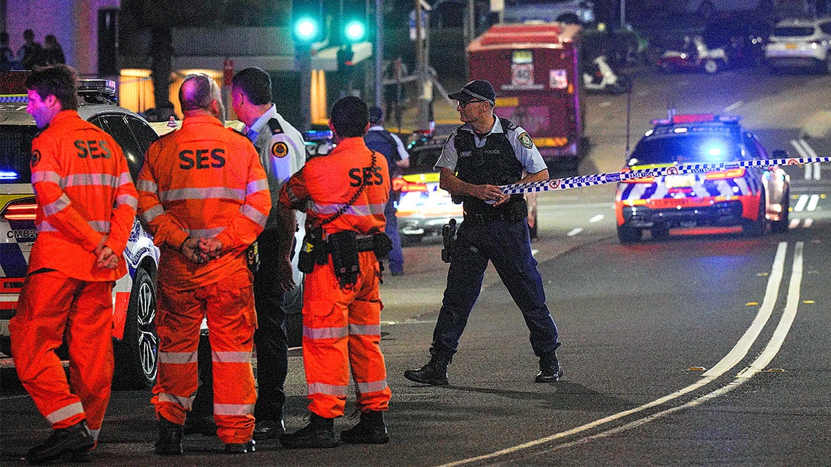 Police officers stand near Bondi Beach as they secure the area following a deadly terrorist attack during the first night of Hanukkah.