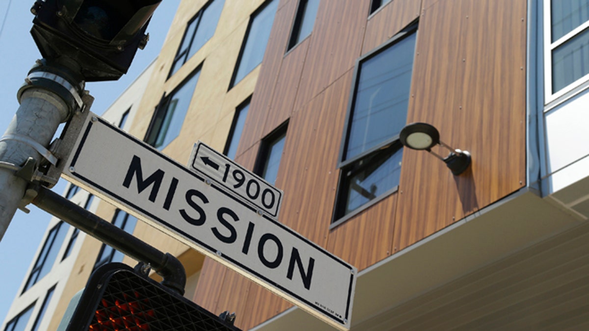 A street sign hangs outside a new apartment building on Mission Street