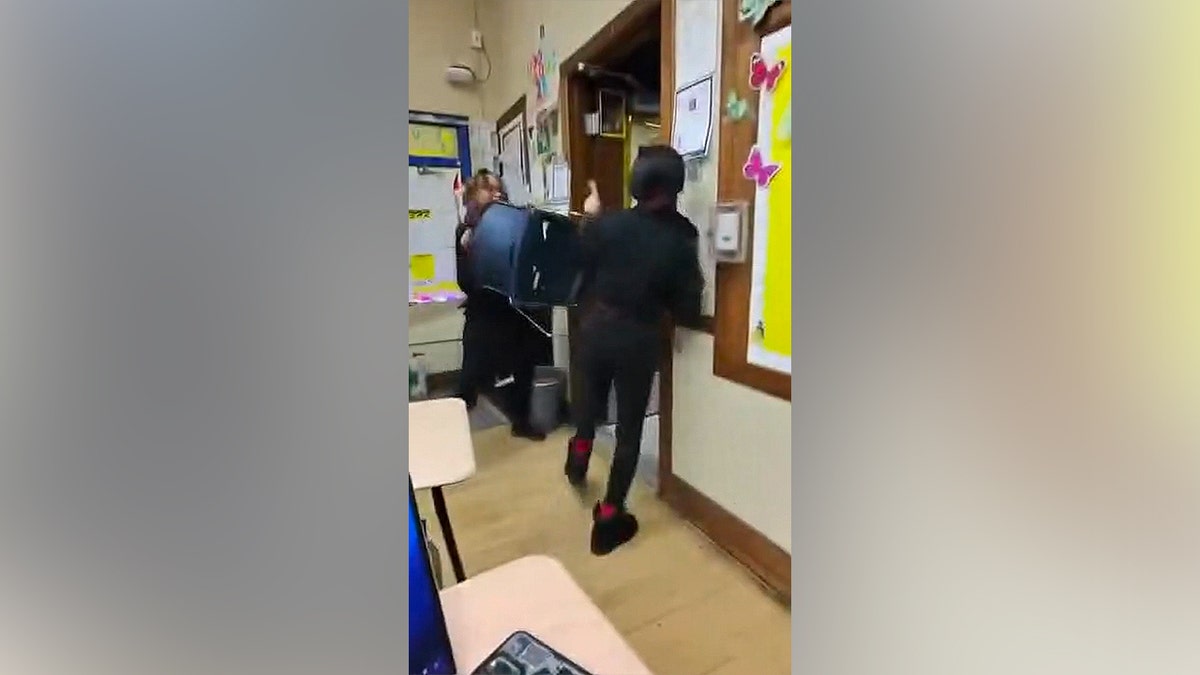A teacher attempting to block a student with a chair