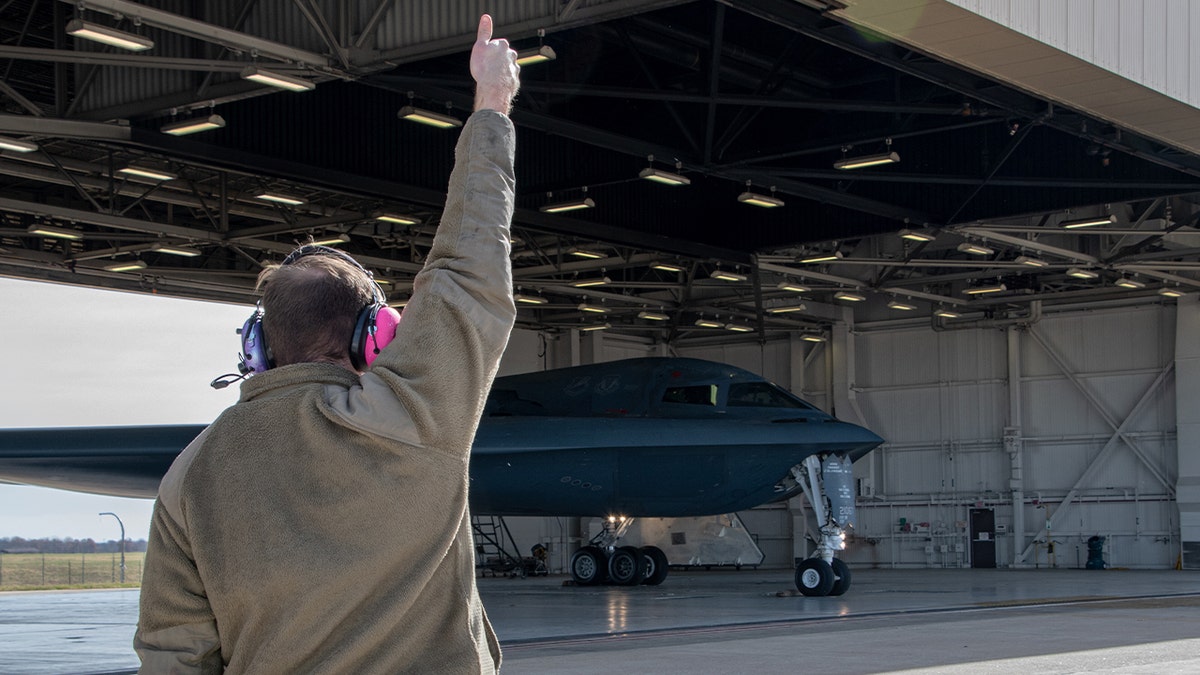 staff member directs a B-2 spirit stealth bomber