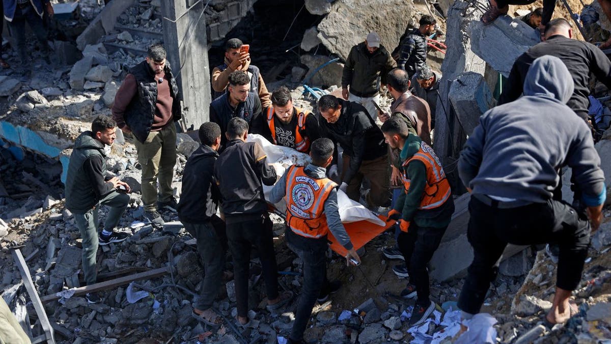 Rescue workers carry a body through rubble after an Israeli airstrike in Gaza City.